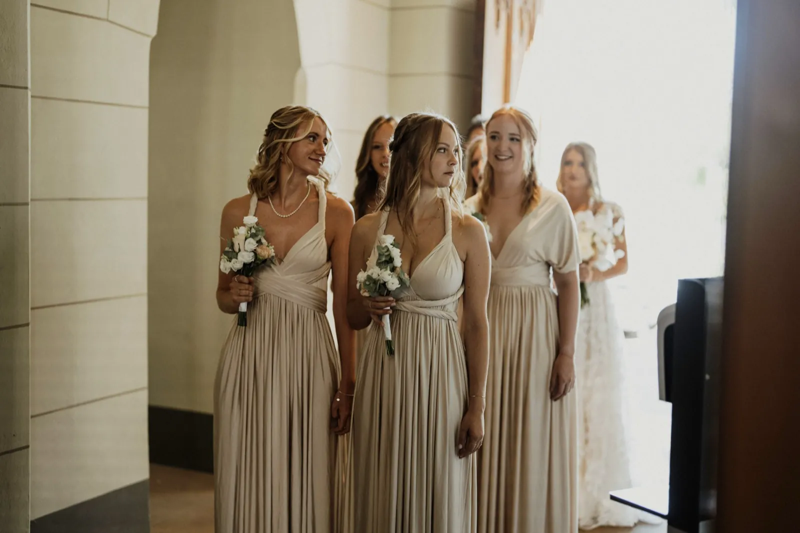 Philina & Damian – Brautjungfern in beigen Kleidern stehen mit Blumensträußen in einer Reihe