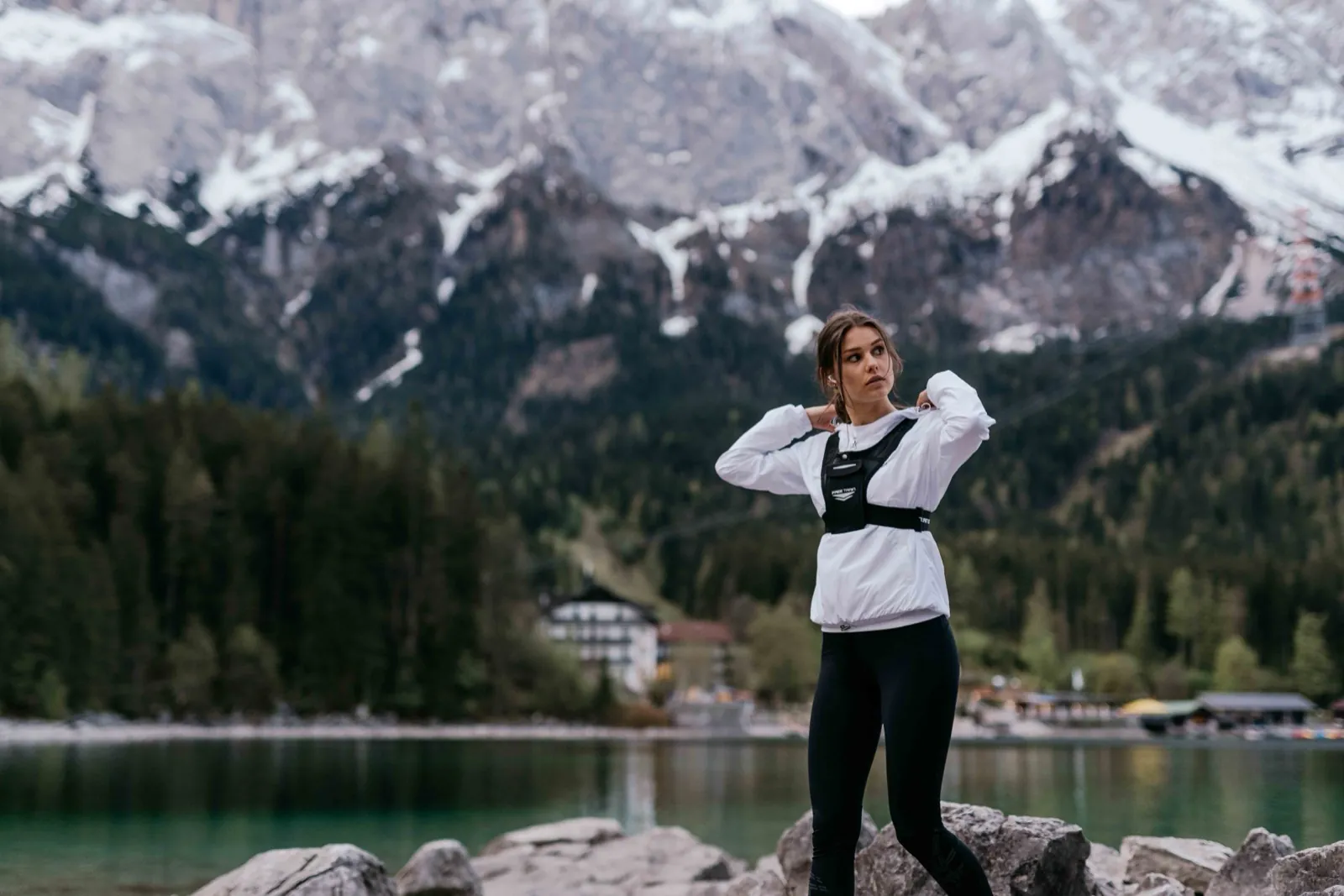 Freetrain – Eine sportliche Frau steht vor einem Bergsee und schneebedeckten Bergen