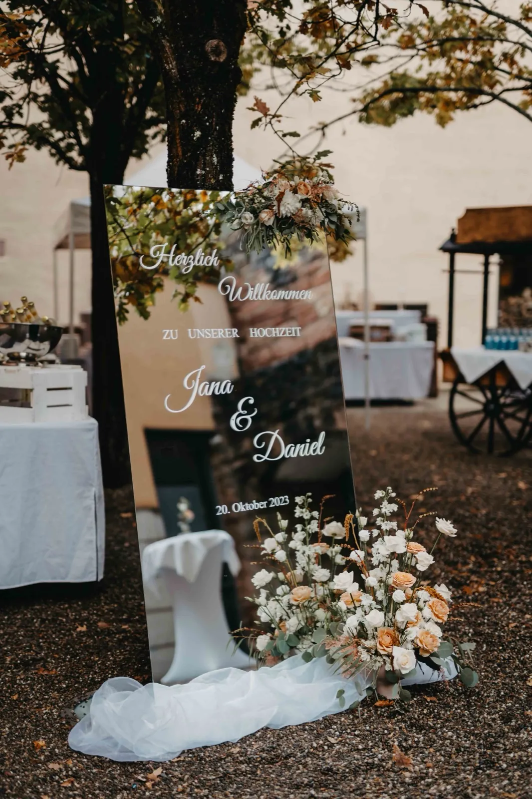 Jana & Daniel – Ein verspiegelter Hochzeits-Willkommensgruß mit Blumendekoration im Freien