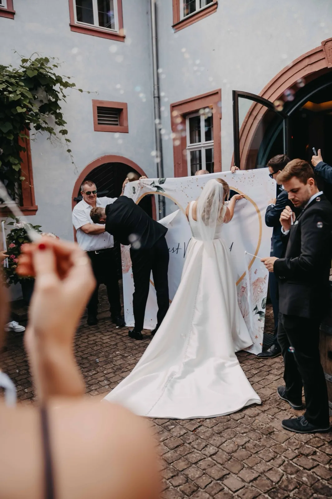 Janina & Alexander – Braut und Bräutigam schneiden gemeinsam ein Herz aus einem großen Laken aus