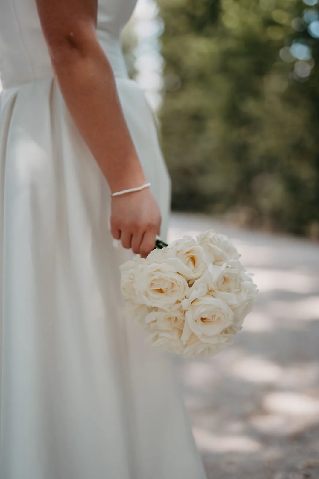 Janina & Alexander – Eine Braut hält einen Strauß aus weißen Rosen in der Hand