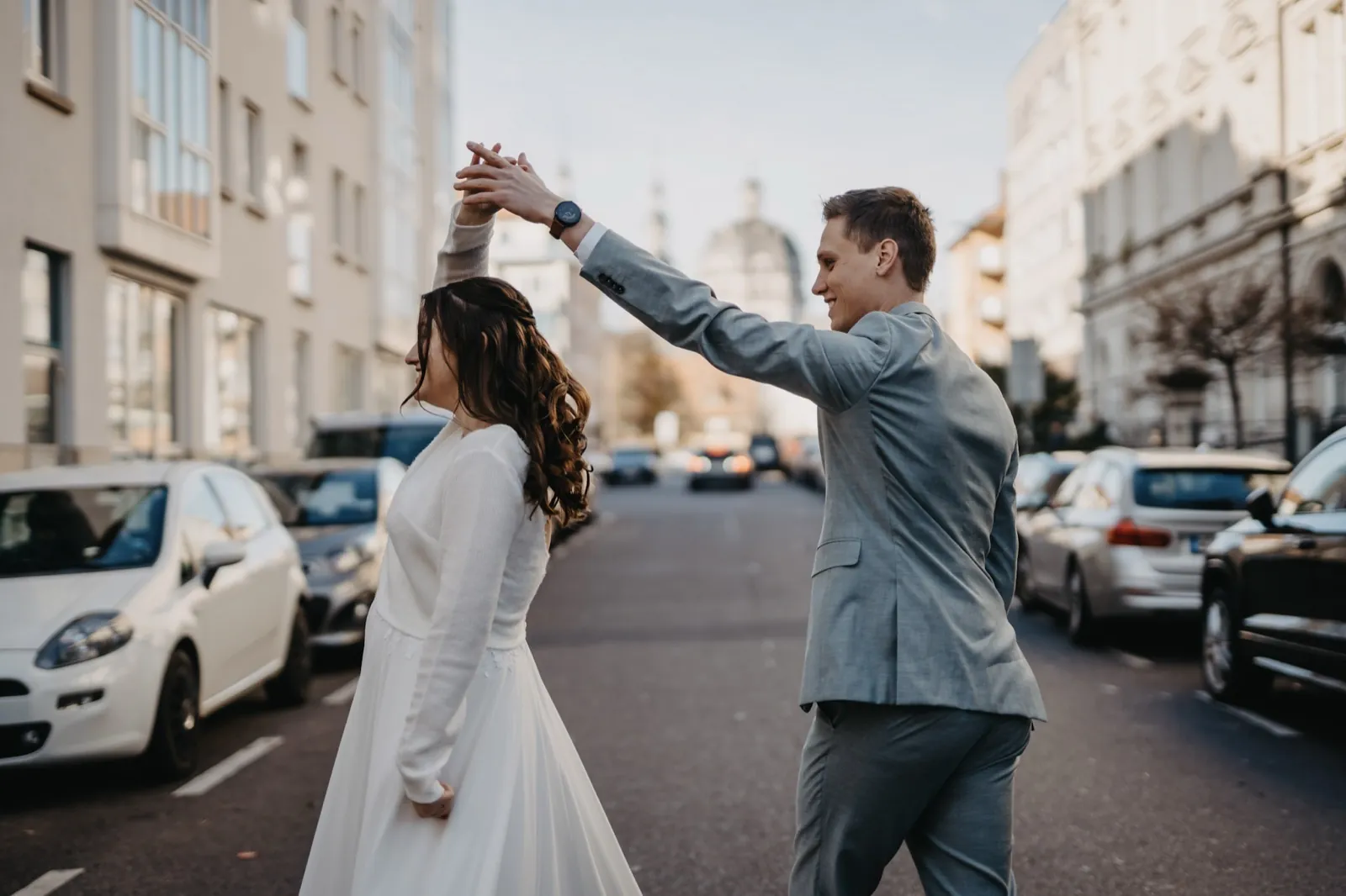 Sophie & Mirko – Ein Brautpaar tanzt ausgelassen auf einer Straße in der Stadt