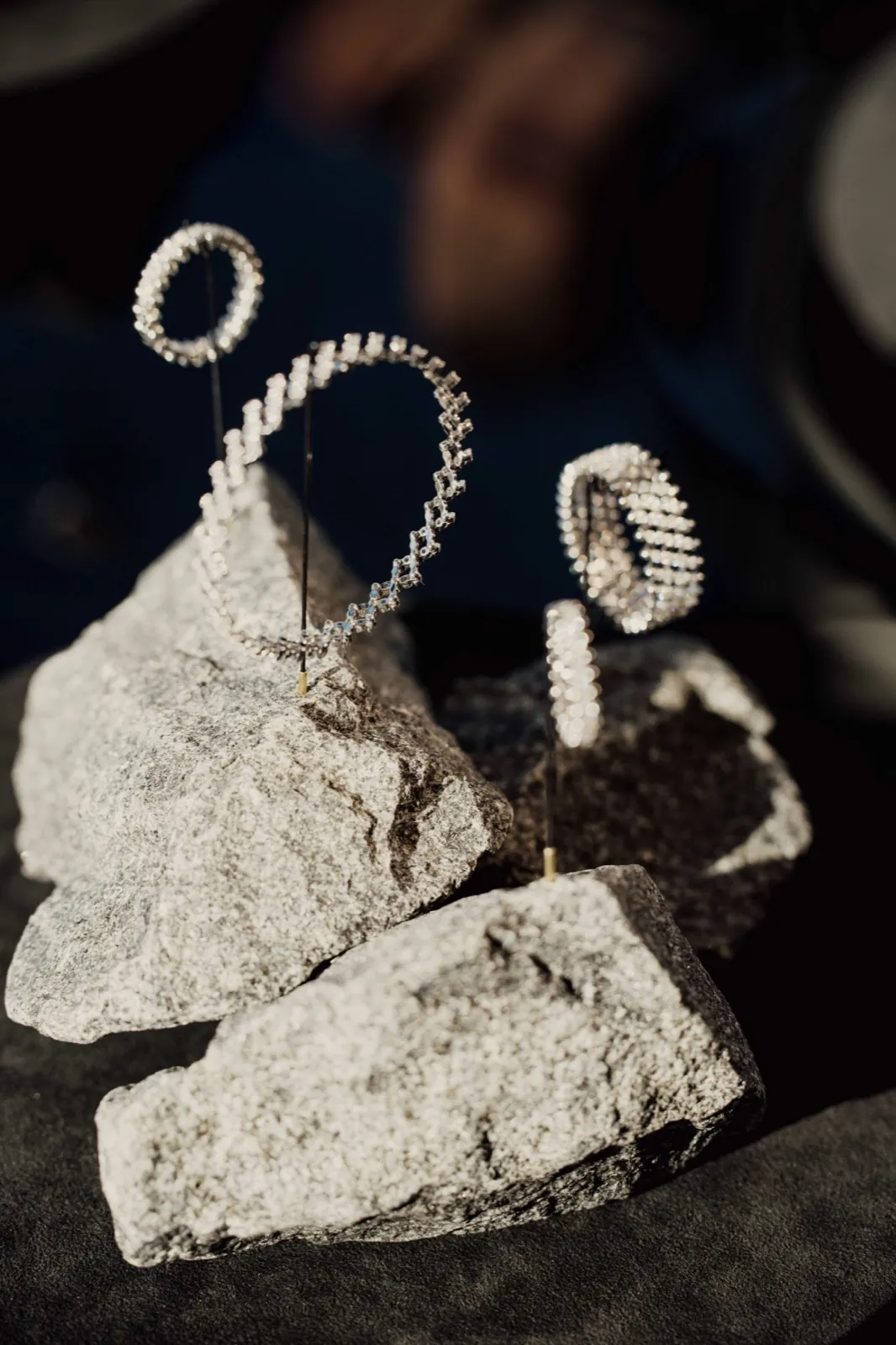Wempe x Serafino Consoli – Filigraner, glitzernder Schmuck ist auf rauen, grauen Steinen kunstvoll präsentiert